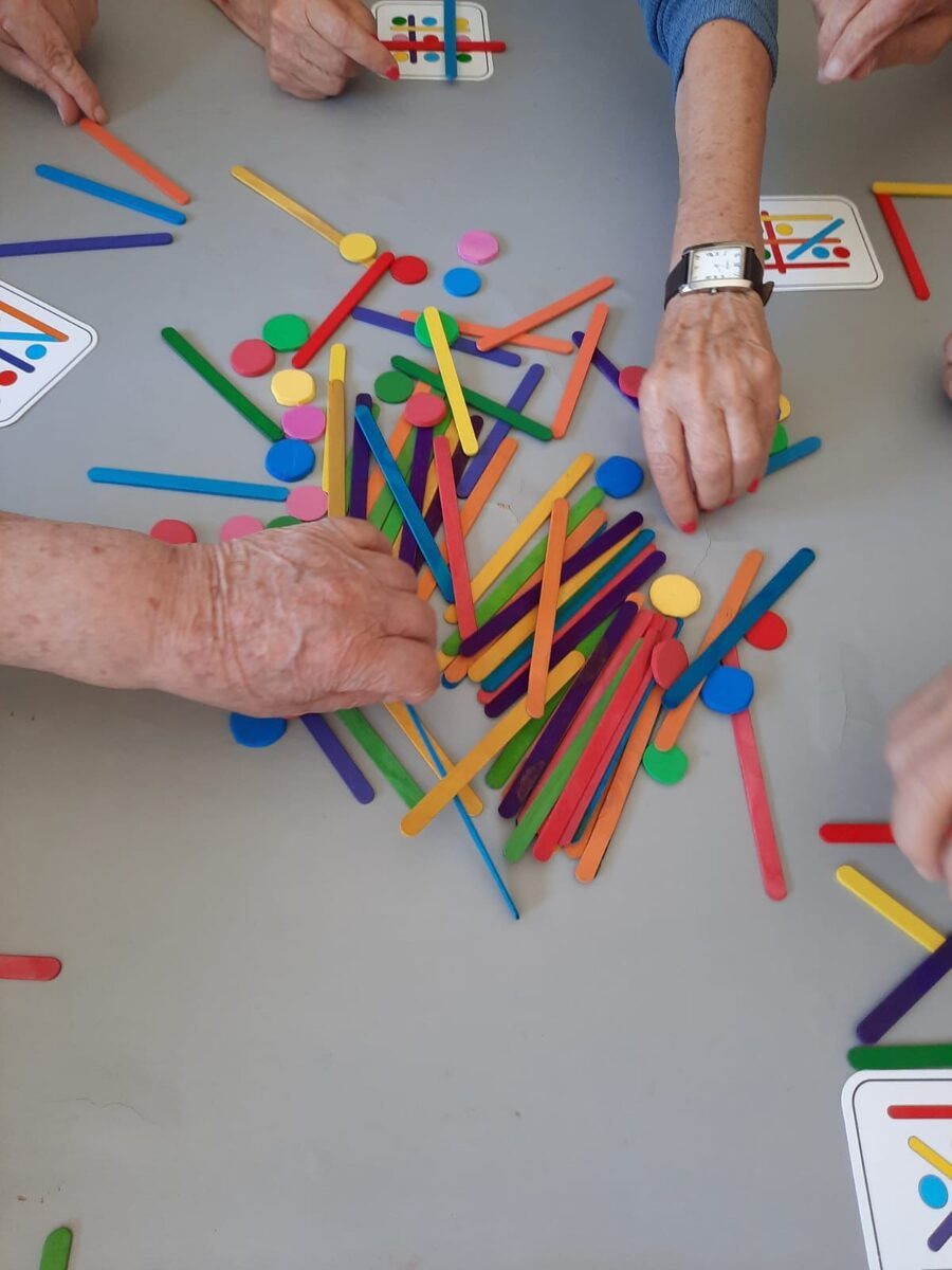 Residentes a jogar com paus coloridos em mesa